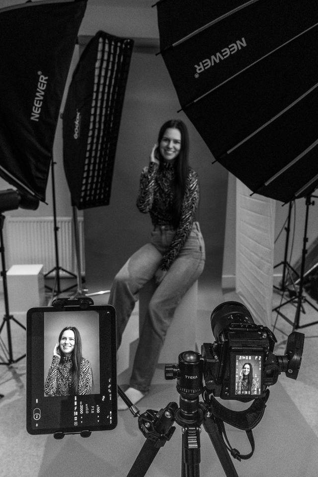 Behind-the-scenes of a portrait session in a dim studio
